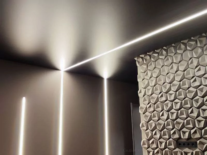 Черный натяжной потолок и всетовые линие переходящие на стену